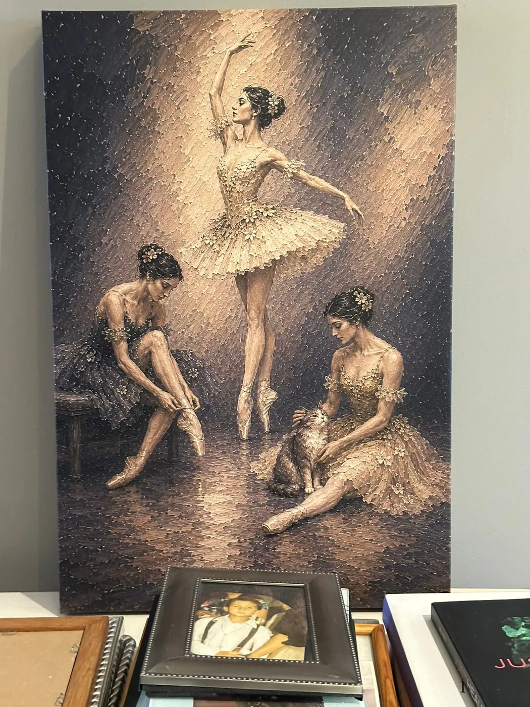 Pieza de bailarinas en canvas con textura, apoyada junto a marcos y libros en el taller